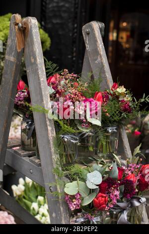 Una varietà di colori vicino al negozio Liberty di Londra. Grandi bouquet in vasi di stagno. Piccoli bouquet per diverse occasioni Foto Stock