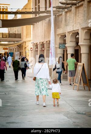 Colpo di ritorno di madre e bambino piccolo che cammina attraverso il mercato a Dubai Creek UAE. Foto Stock