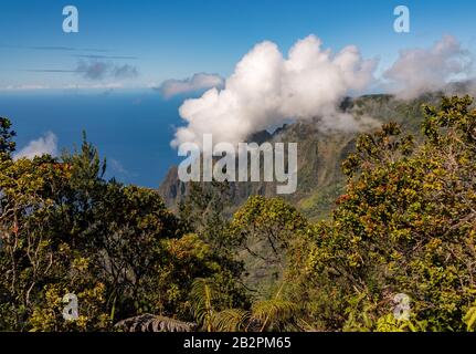 Rocce scanalate dei monti Na Pali con nuvole che si formano sulle cime dal punto panoramico di Kalalau su Kauai Foto Stock