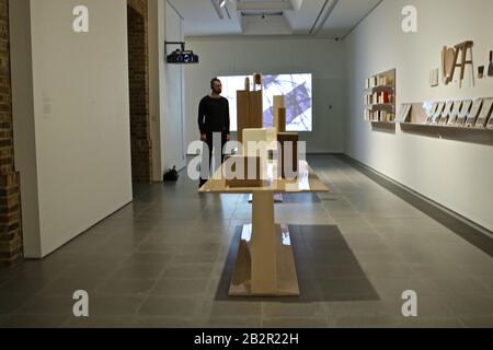 Formafantasma Cambio . La grande mostra di design esplora il legno e le dinamiche globali dell'industria del legno . Lo spettacolo pionieristico collega scienza , conservazione , ingegneria e politica , indaga su come il design possa plasmare un futuro migliore . Cambio di Formfantasma è una nuova mostra di design radicale sul legno. La mostra riunisce film, oggetti, manufatti e campioni, tra cui mobili appositamente progettati realizzati da un unico albero abbattuto durante le tempeste in Val de Fiemme in Italia , campioni di legno prestato da istituzioni di tutto il mondo , Dai Giardini Botanici reali a Kew e altri. Foto Stock