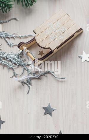 Primo piano di un piccolo ornamento di slitta di legno sul tavolo sotto le luci Foto Stock