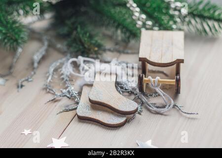 Closeup di una slitta di legno e calze ornamento sul Tavolo circondato da decorazioni natalizie Foto Stock