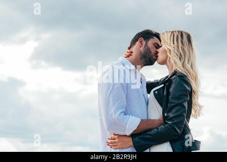 attraente donna e bell'uomo abbracciando e baciare fuori Foto Stock