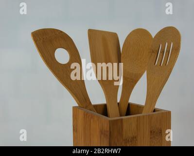 Un cucchiaio da cucina con quattro cucchiai di legno naturale in un contenitore di legno Foto Stock