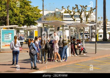 Cannes, FRANCIA - APRILE 2019: Folla di persone in attesa di un autobus alla fermata di un autobus nel centro di Cannes. Foto Stock