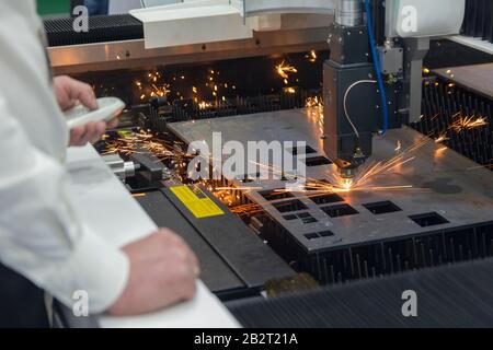 Lavoratore nel taglio laser industriale di lamiera. Industria Foto Stock