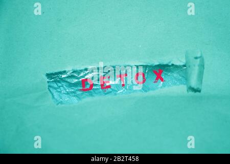 Parola detox scritta sotto carta strappata lettere rosse su sfondo menta Foto Stock