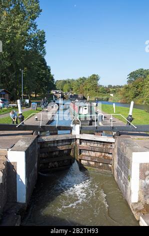 Donna che apre una serratura per una barca a narrowboat o canale sul Canal Grande, Hatton Locks, Hatton, Warwickshire, Inghilterra Foto Stock