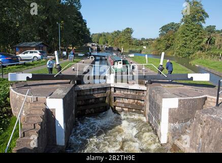 Persone che aprono una serratura per una barca a narrowboat o Canal sul Canal Grande Union Canal, Hatton Locks, Hatton, Warwickshire, Inghilterra Foto Stock