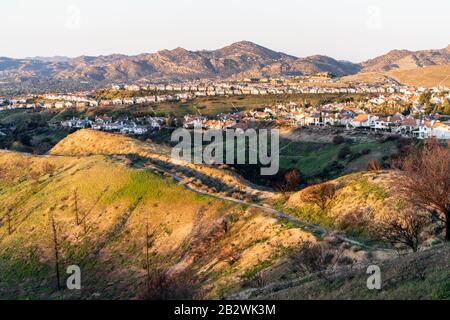 Case in cima alla collina che si affacciano sulla Valle di San Fernando nel nord di Los Angeles, California. I Monti Santa Susana sono sullo sfondo. Foto Stock