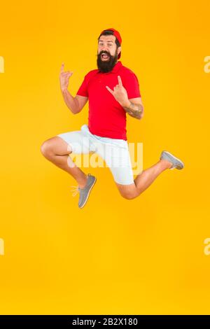 Carica di energia. Sano ragazzo sentirsi bene. Concetto ispirato. Sempre in movimento. Uno stile di vita attivo. Felice ragazzo che salta. Uomo con bearded attivo in movimento sfondo giallo. Hippster attivo ed energetico. Foto Stock