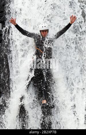 Uomo Cresciuto Discendendo In Una Cascata Shoot Dalla Posizione Liquida Foto Stock