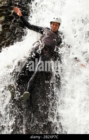 L'Uomo Maturo Discendendo In Una Cascata Shoot Dalla Posizione Bagnata Foto Stock