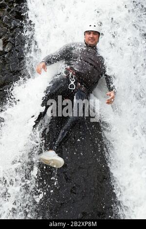 Uomo Maturo Che Discendendo In Una Cascata Shoot Dal Livello Di Liquido Foto Stock