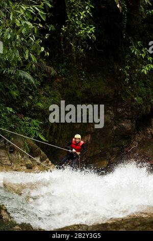 Donna Adulta Indossare Attrezzatura Di Tenuta Descendendo Una Cascata Foto Stock