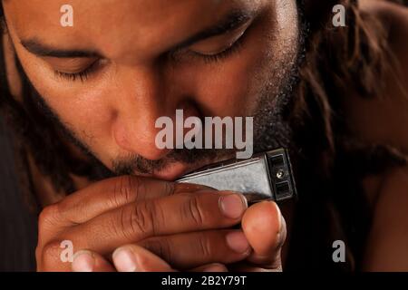 Rastafarian Man Gaming Bocca Armonica Foto Stock