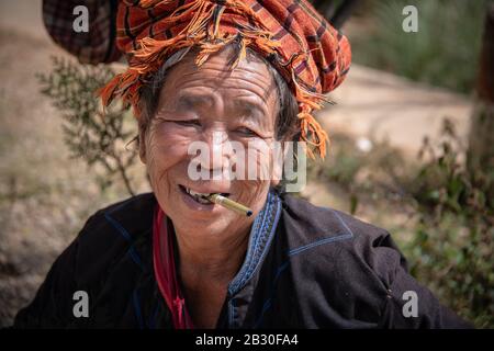 Lago Inle, Myanmar - 02 Febbraio, 2020: Sorridente vecchia signora della tribù delle colline Pa'o che fuma un sigaro nel villaggio di Indein, vicino al lago Inle, Stato Shan. Foto Stock