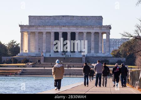 La gente cammina lungo la piscina riflettente verso il Lincoln Memorial. Foto Stock