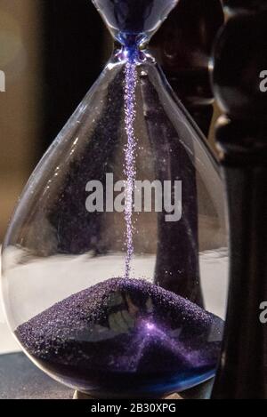 Chiuso di vetro smerigliato o clessidra con sabbia viola e viola Foto Stock