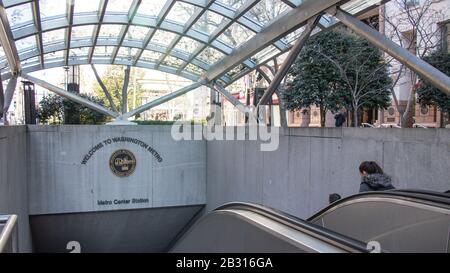 La gente viaggia sulla scala mobile verso una stazione della metropolitana di Washington nel centro di D.C. Foto Stock