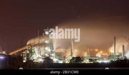 industria pesante vicino alla via d'acqua che causa le emissioni Foto Stock