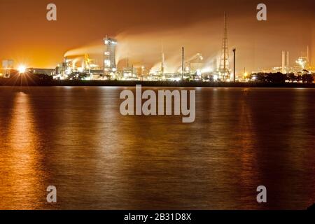 industria pesante vicino alla via d'acqua che causa le emissioni Foto Stock