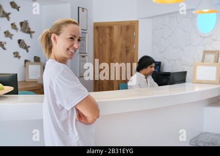 Ritratto dei lavoratori dell'hotel spa, donna vicino alla reception Foto Stock