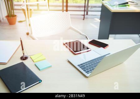 Moderno ambiente di lavoro per ufficio con computer portatile, tablet pc digitale e smartphone sulla scrivania. Apri il notebook, il tablet, lo smartphone Foto Stock