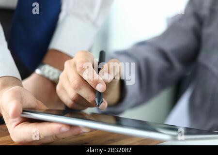 L'uomo tiene lo stilo e inserisce la firma sul tablet Foto Stock