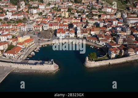 VISTA AEREA. Pittoresca cittadina di Nafpaktos con il suo piccolo porto fortificato. Golfo di Corinto, Grecia occidentale, Grecia. Foto Stock