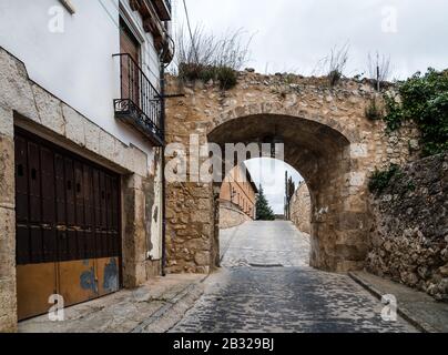 Strada e arco in pietra nella città medievale di Pastrana in Spagna. Foto Stock