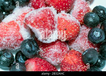 Frutti Di Bosco Congelati - Fragole E Mirtilli Freddi Con Ghiaccio, Primo Piano Macro Foto Stock