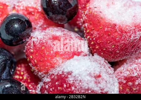 Frutti Di Bosco Congelati - Fragole E Mirtilli Freddi Con Ghiaccio, Primo Piano Macro Foto Stock