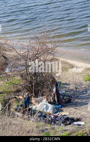 Luogo di soggiorno e per la vita dei senzatetto. Un soggiorno spontaneo di una notte sulla riva del fiume. Problemi sociali. Povertà o migrazione illegale. Senza Foto Stock