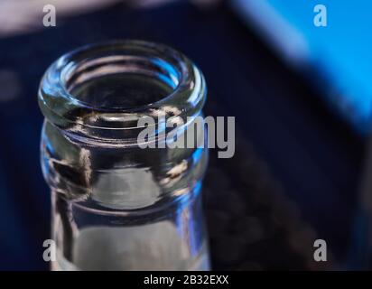 Bottiglia di birra vuota, parte superiore, davanti alla tastiera di un laptop. Nitidezza selettiva. Concetto di abuso di alcool e dipendenza da alcool sul luogo di lavoro Foto Stock