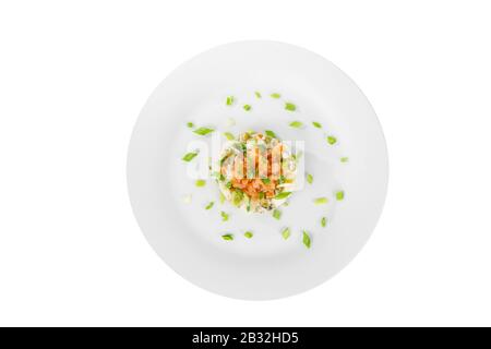 Insalata russa con piselli, pesce rosso, salmone al chum, uova, cetrioli, carote, patate, decorare cipolla verde su piastra, vista dall'alto, bac bianco isolato Foto Stock