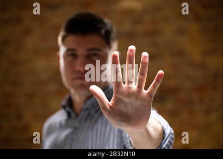Caucasian man with arm raised and hand Foto Stock