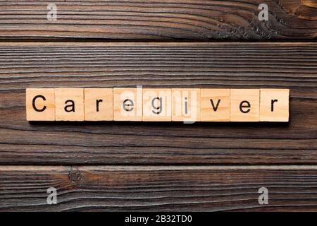Parola dell'operatore sanitario scritta sul blocco di legno. Testo dell'operatore sanitario sul tavolo in legno per il concetto di desing, vista dall'alto. Foto Stock