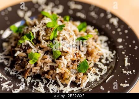 il risotto ai funghi è un tradizionale caposaldo della cucina italiana, preparato con ingredienti biologici Foto Stock