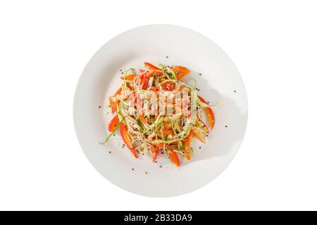 Insalata con carne, pollo, maiale, pepe, tagliatelle, frecce all'aglio, cipolle verdi, pomodoro, carote, zucchine, semi di sesamo su piastra, backgro isolato bianco Foto Stock