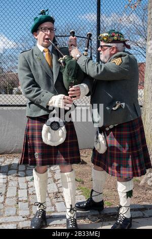 I membri della contea Cork Pipes & Drums sintonizzano i loro strumenti prima di marciare nella parata di San Patrizio a Sunnyside, Queens, New York. Foto Stock