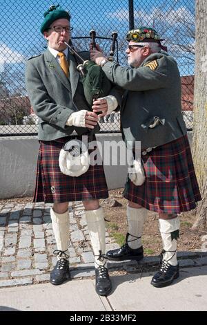 I membri della contea Cork Pipes & Drums sintonizzano i loro strumenti prima di marciare nella parata di San Patrizio a Sunnyside, Queens, New York. Foto Stock