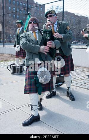 I membri della contea Cork Pipes & Drums sintonizzano i loro strumenti prima di marciare nella parata di San Patrizio a Sunnyside, Queens, New York. Foto Stock