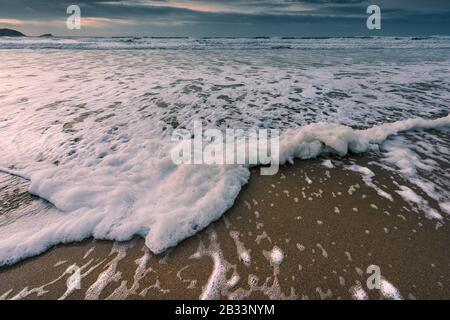 Marea in arrivo in una fredda serata fredda a Fistral Beach a Newquay in Cornovaglia. Foto Stock