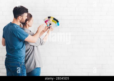 Giovane coppia che discute una ristrutturazione di una casa con tavolozza di colori Foto Stock