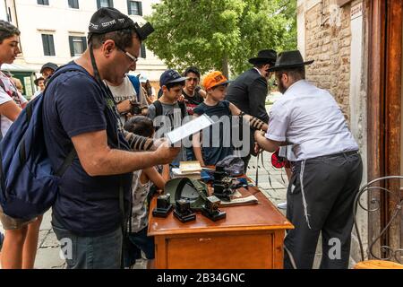 Visitatori ebrei che indossano Il Tefillin durante la preghiera del mattino nei giorni feriali, nel ghetto ebraico, campo de Ghetto Novo, Venezia, Italia, 2019. Foto Stock