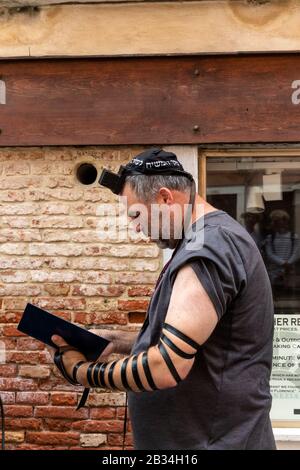 Visitatori ebrei che indossano Il Tefillin durante la preghiera del mattino nei giorni feriali, nel ghetto ebraico, campo de Ghetto Novo, Venezia, Italia, 2019. Foto Stock