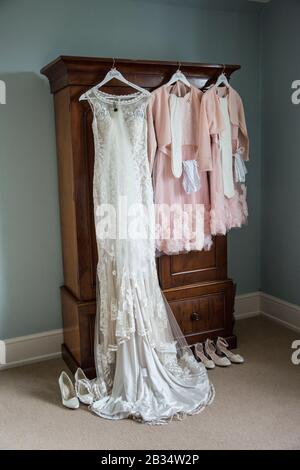 Abito da sposa e abiti da sposa appendere in attesa di essere indossato il giorno del matrimonio sposa a Hereford Inghilterra Foto Stock