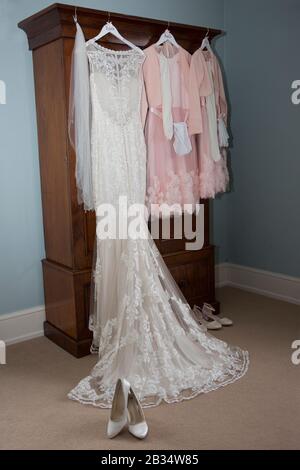 Abito da sposa e abiti da sposa appendere in attesa di essere indossato il giorno del matrimonio sposa a Hereford Inghilterra Foto Stock