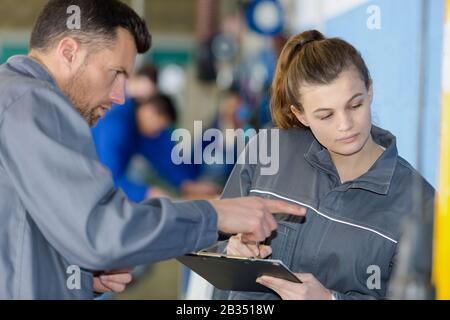 apprendista femminile in tute che contengono un portadocumenti Foto Stock